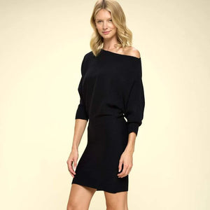 Side view of an chic black mini sweater dress featuring an off-the-shoulder neckline, ribbed texture, and fitted cuffs, showcasing a versatile design for a night out or New Year’s Eve Party.